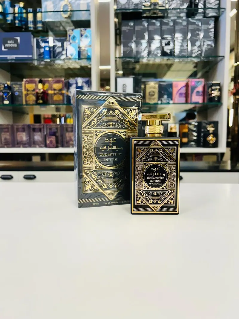 Perfume árabe Oud Mystery Intense, frasco preto e dourado ao lado da caixa
