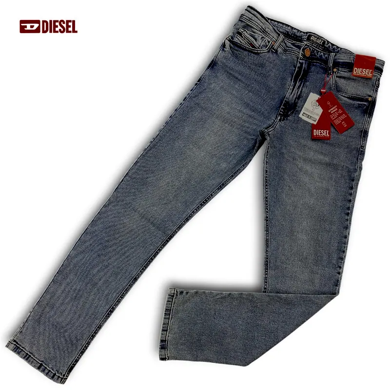 Calça jeans Diesel azul-clara inteira, aberta no fundo branco, com as etiquetas vermelhas
